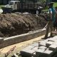 Workers building retaining wall with bricks and tools.